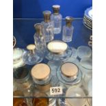 A SET OF 8 GLASS SCENT BOTTLES WITH GLASS STOPPERS AND PLATED TOPS 14 X 11 CMS