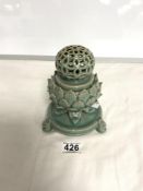 AN ORIENTAL GREEN GLAZED INCENSE BURNER WITH LOTUS LEAF DECORATION AND PIERCED CYLINDRICAL LID ON