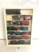 A QUANTITY OF MODEL VEHICLES IN A WALL MOUNTED DISPLAY CABINET