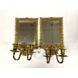 A PAIR OF EARLY 20TH CENTURY ORNATE BRASS MIRRORED TWO BRANCH WALL SCONCES, 22 X 34CMS