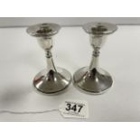 A PAIR OF SILVER CIRCULAR CANDLESTICKS WITH WOOD FILLED BASES, BIRMINGHAM 1917