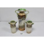 A GARNITURE OF THREE ROYAL DOULTON DICKENS WARE CYLINDRICAL TWO HANDLED VASES, THE LARGEST 27CMS