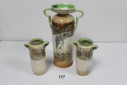 A GARNITURE OF THREE ROYAL DOULTON DICKENS WARE CYLINDRICAL TWO HANDLED VASES, THE LARGEST 27CMS