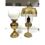 AN ORNATE EMBOSSED BRASS OIL LAMP (CONVERTED TO ELECTRIC), SHADE HAVING COLOURED STONES INSET AND