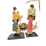 TWO JAPANESE FIGURES IN DRESS UNDER A CYLINDRICAL GLASS CASE, 38CMS