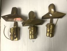 A SET OF THREE BRASS WALL MOUNTED ELECTRIC LAMPS