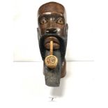 AN AFRICAN CARVED WOODEN BUST OF A MAN SMOKING A PIPE, 40CMS