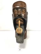 AN AFRICAN CARVED WOODEN BUST OF A MAN SMOKING A PIPE, 40CMS