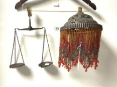 A METAL AND BEADED DROP HANGING LIGHT AND A SMALL SET OF BALANCE SCALES