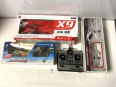 THREE REMOTE CONTROL HELICOPTERS IN BOXES AND A REMOTE CONTROLLER UNIT IN A BOX