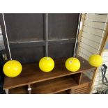 A SET OF FOUR YELLOW GLOBULAR HANGING LIGHTS