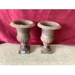 CAST IRON A PAIR OF SMALL GARDEN URNS WITH FLUTED DECORATION ON PLINTH BASES, 34 X 24CMS