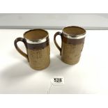 A PAIR OF DOULTON LAMBETH STONEWARE HARVESTWARE TANKARDS WITH HALLMARKED SILVER RIMMS