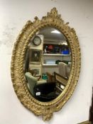 A LARGE VINTAGE OVAL BEVELLED MIRROR SHELL STYLE FRAME, 113 X 76CMS
