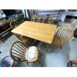 A MODERN DINING TABLE AND SIX MATCHING STICK BACK CHAIRS