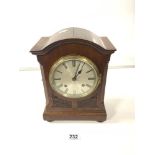 AN EDWARDIAN MAHOGANY CHIMING MANTEL CLOCK WITH A SILVERED DIAL AND CARVED FREEZE ON BUN FEET WITH