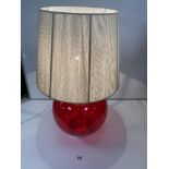 A LARGE RED GLASS GLOBULAR-SHAPE TABLE LAMP