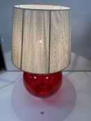 A LARGE RED GLASS GLOBULAR-SHAPE TABLE LAMP