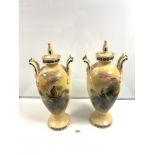 A PAIR OF TALL LATE VICTORIAN TWO HANDLED AND LIDDED URN-SHAPE VASES DECORATED WITH PHEASANTS IN