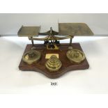 A LARGE SET OF LATE VICTORIAN BRASS LETTER AND PARCEL SCALES ON OAK BASE WITH WEIGHTS