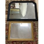 A BLACK PAINTED FRAMED MIRROR 74 X 94CMS AND A GILT FRAMED WALL MIRROR