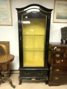 AN EBONISED PAINTED AND GILT DECORATED GLASS FRONT AND SIDES DISPLAY CABINET ON BALL & CLAW FEET, 70