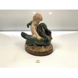 A GLAZED MAJOLICA FIGURE OF A CHERUB ON A SWAN, 24CMS