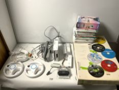 A NINTENDO WII FIT IN BOX AND A QUANTITY OF WII GAMES AND CONTROLLERS AND LEADS
