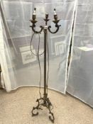 AN ORNATE BRASS THREE BRANCH ELECTRIC LAMP STAND ON ORNATE BRASS LEGS