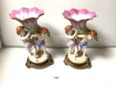 A PAIR OF 20TH CENTURY CERAMIC FIGURES OF CHERUBS HOLDING SHELL, BEARING THE SEVRES MARK TO BASE,