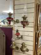 A PAIR OF VICTORIAN BRASS WALL MOUNTED OIL LAMPS WITH RUBY GLASS FONTS, A SMALLER WALL MOUNTED BRASS