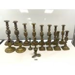 SEVEN PAIRS OF VICTORIAN DIAMOND PATTERN GRADUATING BRASS CANDLESTICKS, THE TALLEST 32CMS, AND