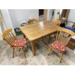 A MODERN PINE KITCHEN TABLE ON TURNED LEGS AND FOUR SPINDLE BACK CHAIRS, 122 X 90CMS