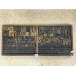 A VINTAGE WOODEN PRINTERS TRAY CONTAINING A QUANTITY OF WOODEN LETTERS