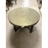 AN EASTERN BRASS ROUND TABLE WITH FOLDING BARLEY TWIST FRAME