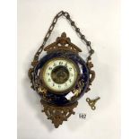 A BLUE AND GILT PORCELAIN HANGING CLOCK WITH GILT METAL MOUNTS ON CHAIN, 22CMS IN DIAMETER