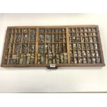 A VINTAGE PRINTERS TRAY WITH A QUALITY OF RUBBER AND METAL PRINTERS LETTERS AND NUMBERS