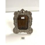 A WHITE METAL PHOTO FRAME, ORNATLEY EMBOSSED WITH ANGELS AND CLASSICAL DECORATION, 22.5 X 18CMS