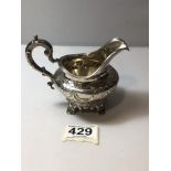 EARLY VICTORIAN HALLMARKED SILVER EMBOSSED CIRCULAR CREAM JUG, WITH SCROLL HANDLE ON SHELL DECORATED