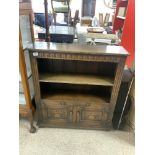 A CARVED DISTRESSED OAK DWARF BOOKCASE WITH CUPBOARD UNDER, 84 X 92CMS