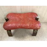 A CAMEL SEAT WITH BRASS STUDS AND RED LEATHER CUSHION