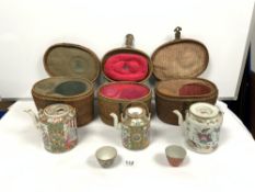 THREE EARLY 20TH CENTURY CHINESE CANTON TEAPOTS IN FITTED CANE CASES