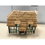 A TUDOR STYLE DOLLS HOUSE WITH THATCHED ROOF AND CONTAINS FURNITURE, FIGURES, FIXTURES & FITTINGS