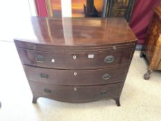 REGENCY MAHOGANY THREE DRAWER AND BRUSHING SLIDE BOW FRONT CHEST, ON SPLAY FEET, WITH RING HANDLES