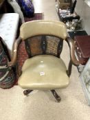 LEATHER AND CANE WORKED SWIVEL CAPTAINS CHAIR ON CASTORS