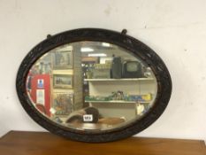 ANTIQUE CARVED WOODEN FRAMED BEVELLED WALL MIRROR IN OVAL FORM, 71 X 50CMS