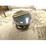 A BRASS AND PAINTED DRUM AND STICKS WITH GLASS TO USE AS COFFEE TABLE