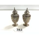 A PAIR OF VICTORIAN HALLMARKED SILVER EMBOSSED BALUSTER-SHAPE PEDESTAL PEPPERS 10.5 CMS BIRMINGHAM