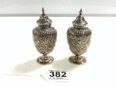 A PAIR OF VICTORIAN HALLMARKED SILVER EMBOSSED BALUSTER-SHAPE PEDESTAL PEPPERS 10.5 CMS BIRMINGHAM