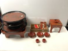 20TH CENTURY JAPANESE RED AND GOLD LACQUERED TRAYS, SMALL CABINET, SAUCERS, MINIATURE CABINET ETC
